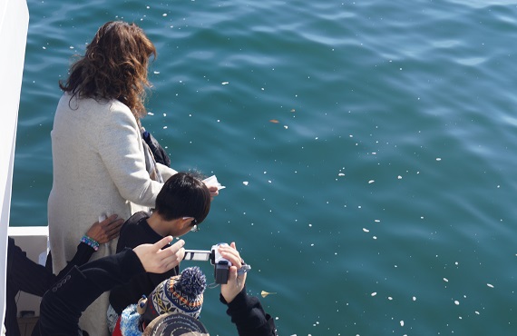 遺骨を東京湾に散骨する女性と見守る家族