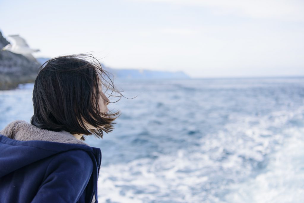 船から海を見つめる女の子