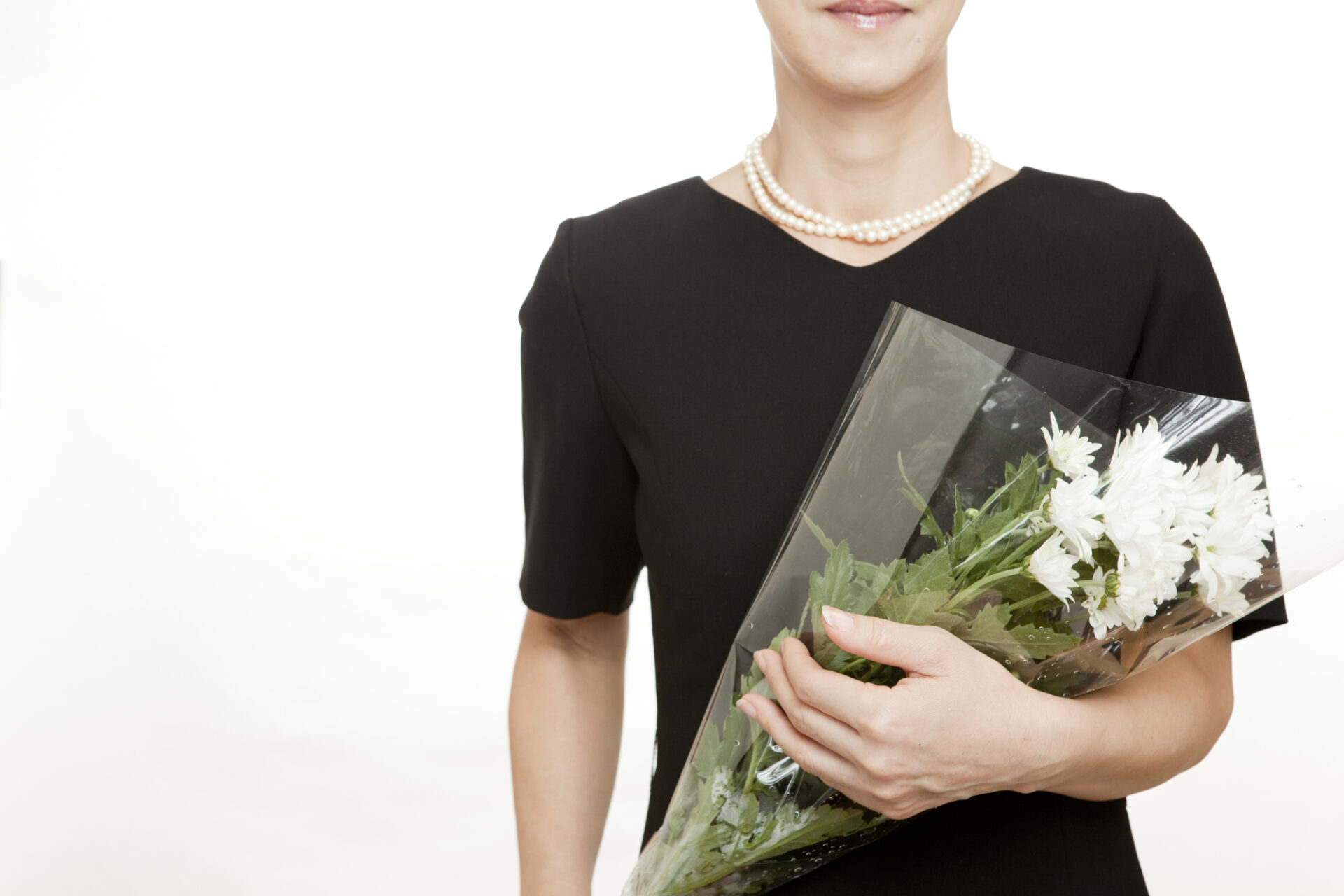 喪服を着て白い花を持つ女性