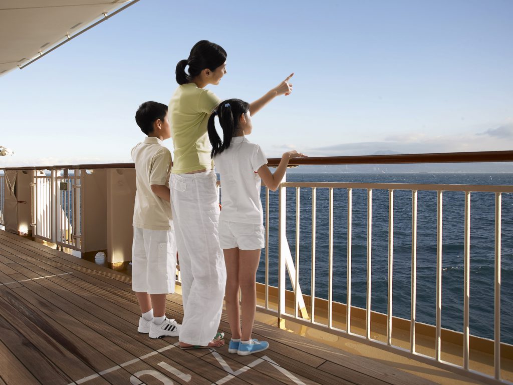 船から海を見ている親子3人