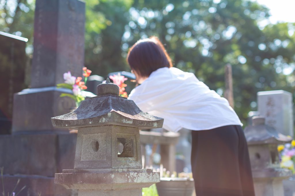 女性がお墓で供養している