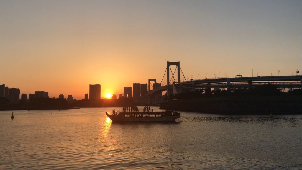 夕日に照らされた東京湾と船
