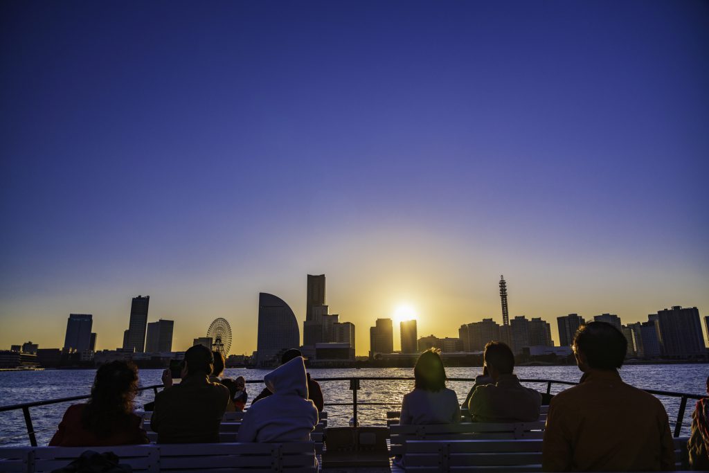 船のデッキに座り景色を眺める人たち