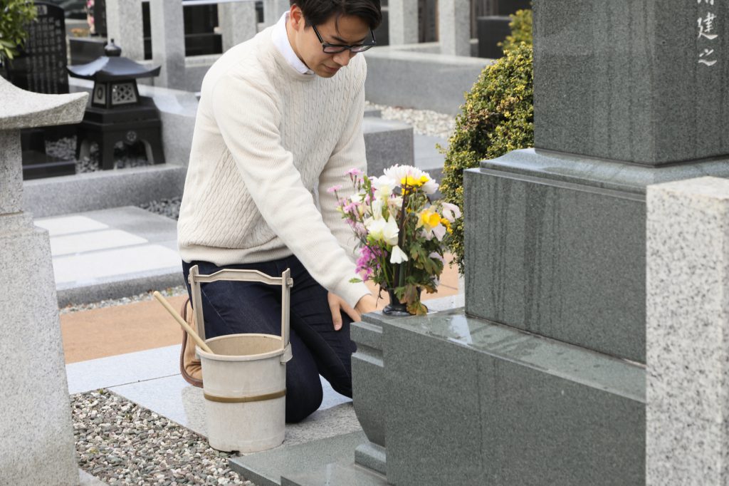 一人でお墓のお手入れをする男性