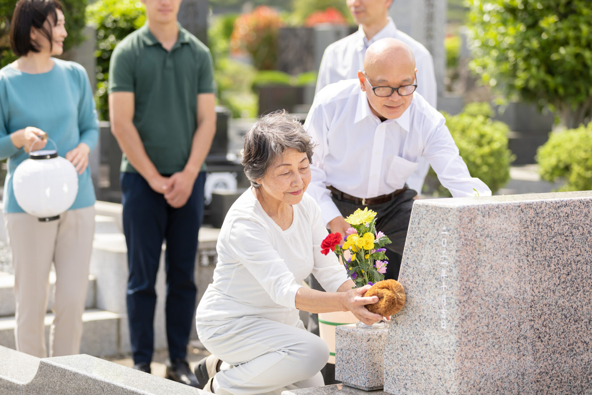 お墓を掃除している老夫婦