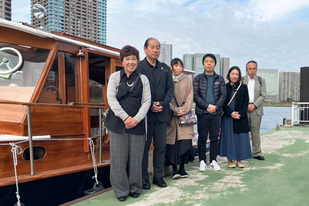 越中島桟橋で家族が小型クルーザーと一緒に記念写真