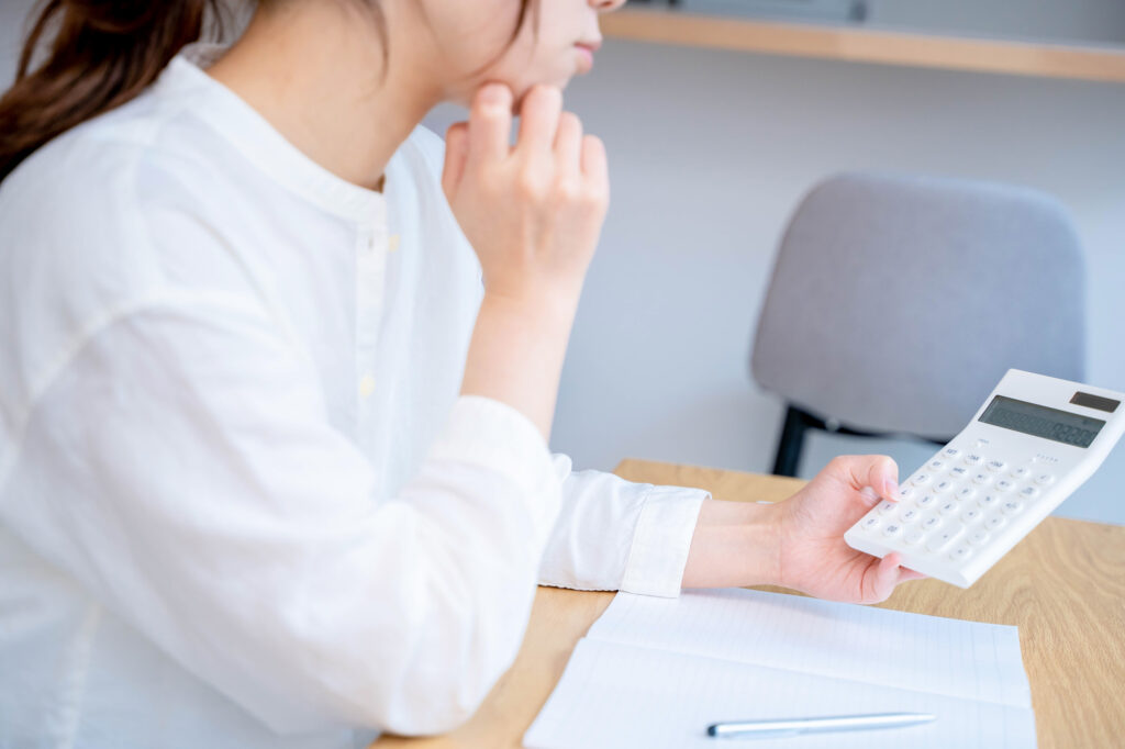 電卓を見て悩む女性