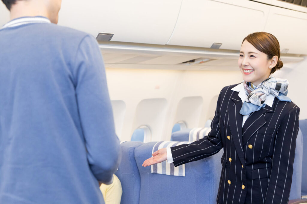 機内で案内をするキャビンアテンダント